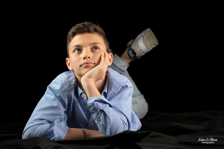Photo studio enfant garçon allongé pensif